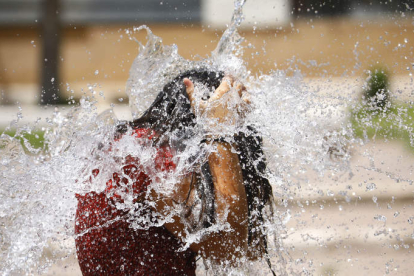 Una niña se refresca en una fuente en Córdoba. SALAS