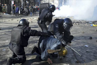 Tres policías detienen a uno de los manifestantes, en Kiev.