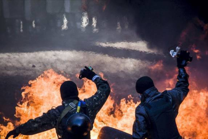 Dos manifestantes arrojan cócteles molotov durante las protestas.