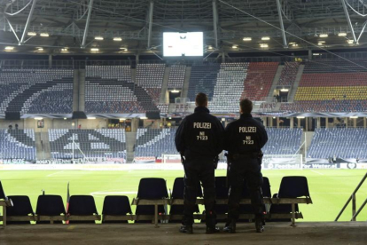 Dos agentes de la policía permanecen en las gradas antes del partido amistoso entre Alemania y Holanda en el IDH-Arena en Hannover, que ha sido evacuado