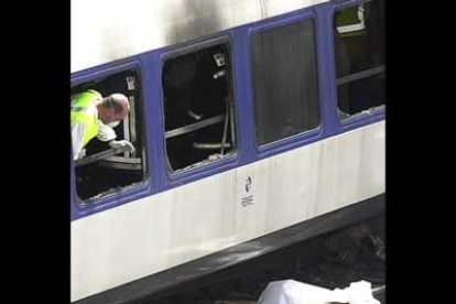 Un efectivo de los Cuerpos de Seguridad inspecciona desde dentro el estado de uno de los vagones.