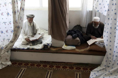 Musulmanes afganos leen versos del Corán en una mezquita de la ciudad de Kabul. /