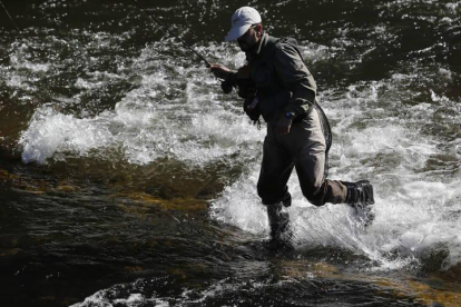 Un pescador en un río leonés