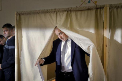 Borisov, líder del centroderechista GERB, tras votar en una cabina electoral, en Sofía, el 26 de marzo.