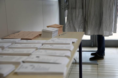 Un ciudadano ejerce su derecho al voto en la cabina junto a la mesa en la que se depositan las papeletas de todos los partidos. ANA ESCOBAR
