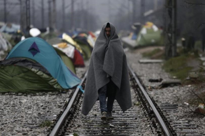 Un refugiado envuelto en una manta, en un campo de refugiados en la frontera entre Grecia y Macedonia, cerca de Idomeni (Grecia), este jueves.