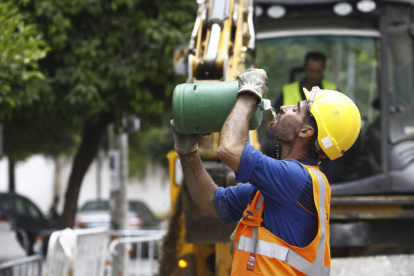 Un trabajador de la construcción bebe agua durante la jornada de trabajo en plena ola de calor. SALAS