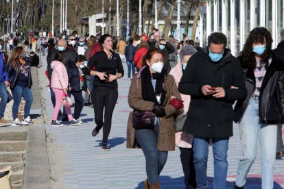 Numerosas personas aprovechan el soleado Día de Navidad para pasear por el paseo de la Playa de Samil de Vigo. SALVADOR SAS