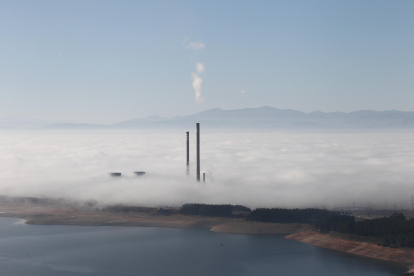Una imagen que no se volverá a repetir. Las tres chimeneas y dos torres de refrigeración asoman en la orilla del embalse de Bárcena un día de niebla. L. DE LA MATA