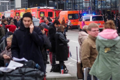 Bomberos y pasajeros evacuados del aeropuerto de Hamburgo.