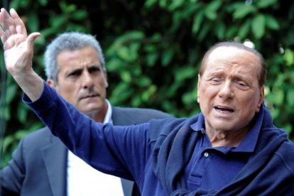 Silvio Berlusconi saluda a sus seguidores al salir del hospital.