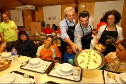 Azuara y José Luis Ramón sirven una ensaladilla a los niños del campamento del Bosque de los Sueños