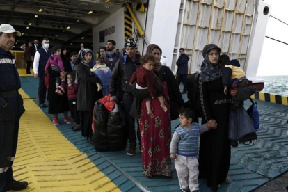 Refugiados y migrantes desembarcan del ferri 'Eleftherios Venizelos' a su llegada al puerto de Elefsina, a 20 kilómetros al noroeste de Atenas, procedentes de Lesbos, este lunes.