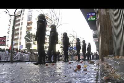 Miembros de la Policia Nacional custodian la sede del Partido Popular en Barcelona donde miles de personas se han concentrado y han lanzado huevos y otros objetos para exigir el final de la guerra.