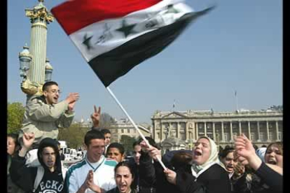 Manifestantes gritan consignas contra la guerra e izan una bandera iraquí ante la Embajada de Estados Unidos en la Plaza de la Concordia de París.