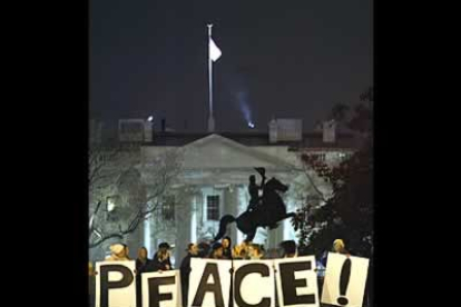 Manifestantes portan pancartas a favor de la paz frente a la Casa Blanca tras haber anunciado George Bush el comienzo de la guerra.