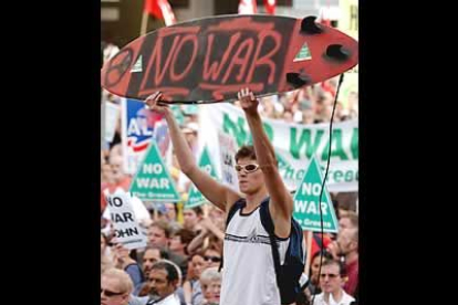 Un joven australiano usa su tabla de surf como pancarta contra la guerra en Irak durante una manifestación que reuníó a miles de personas en Sidney.