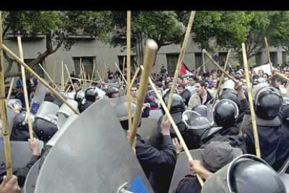 Policías egipcios cargan contra los manifestantes reunidos contra el ataque a Irak en la ciudad de El Cairo.