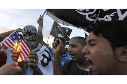 Manifestantes libios queman una bandera de EEUU en protesta por la detención de Al-Libi, en Benghazi.
