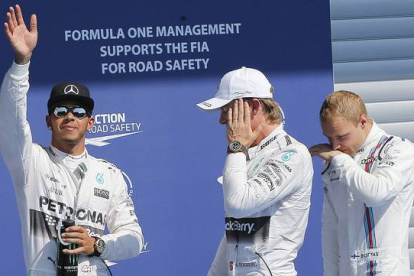 Lewis Hamilton, 'pole' en Spa, saluda a los aficionados junto a Nico Rosberg y Valtteri Bottas.