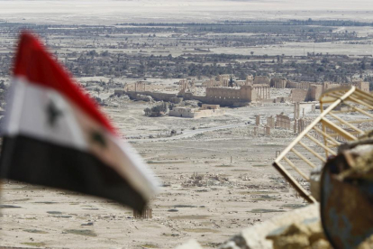 Una bandera siria ondea ante las ruinas de la histórica ciudad de Palmira.