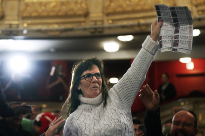 Una mujer del público celebra ser portadora de un quinto premio durante el sorteo de Navidad celebrado en el Teatro Real en Madrid. JAVIER LIZÓN