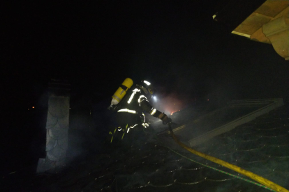 Un bombero trata de sofocar las llamas en el incendio de una vivienda en La Ribera de Folgoso, AYUNTAMIENTO DE PONFERRADA