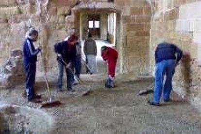 Los voluntarios limpian la parte del antiguo comedor de los monjes del monasterio de Sandoval