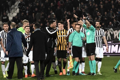 Árbitros y jugadores, durante los incidentes en el tramo final del partido en campo del PAOK.