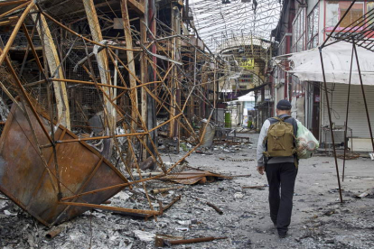 Un hombre pasa por las ruinas del mercado de Barabashovo el más grande de Ucrania. SERGEY KOZLOV