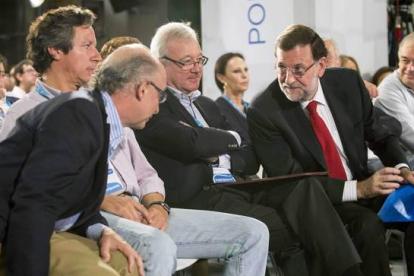 Rajoy habla con Cristóbal Montoro ante el presidente del PP de Murcia, Ramón Luis Valcárcel, y Carlos Floriano, durante la Intermunicipal del PP, este domingo en Murcia