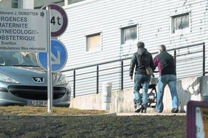 Dos personas se dirigen con un cochecito de bebé a la puerta de entrada del hospital de Chambéry, en los Alpes franceses.