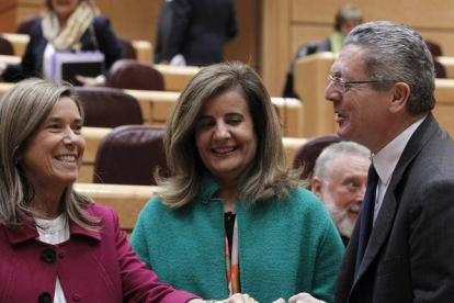 El ministro de Justicia, Alberto Ruiz-Gallardón, conversa con la ministra de Empleo, Fátima Báñez, y la de Sanidad, Ana Mato (i), momentos antes del inicio de la sesión de control al Gobierno, hoy en el pleno del Senado.