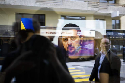 El reflejo de Volodímir Zelenski en una pantalla en la ciudad suiza de Davos. GIAN EHRENZELLER