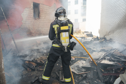 Los bomberos de León intervienen en un incendio en un patio con diferentes enseres en la calle Papa León XIII de la capital. CAMPILLO