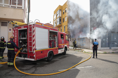 Los bomberos de León intervienen en un incendio en un patio con diferentes enseres en la calle Papa León XIII de la capital. CAMPILLO