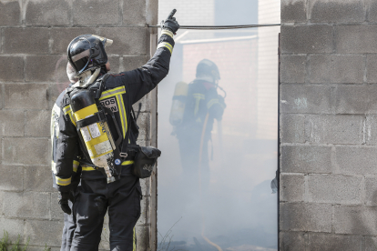Los bomberos de León intervienen en un incendio en un patio con diferentes enseres en la calle Papa León XIII de la capital. CAMPILLO
