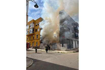 Los bomberos de León intervienen en un incendio en un patio con diferentes enseres en la calle Papa León XIII de la capital. DL