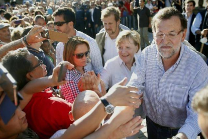 El presidente del Gobierno, Mariano Rajoy (d), y la canciller alemana, Angela Merkel (2d), reparten saludos a su llegada hoy a la plaza del Obradoiro.