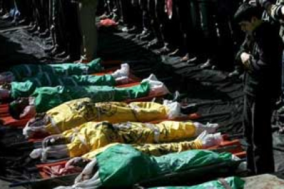 Numerosos palestinos rezan junto a los cuerpos de los 43 palestinos asesinados en un ataque israelí.