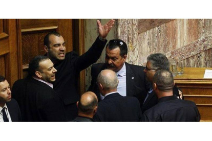 Iliópulos (tercero por la izquierda) abandona el pleno acompañado por miembros de su partido tras ser expulsado, ayer en Atenas.