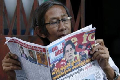 Un birmano lee un periódico donde Suu Kyi aparece en portada, este sábado.