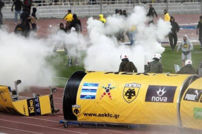 La policía lanza gases lacrimógenos para disolver la invasión de campo de los ultras del AEK en el Estadio Olímpico de Atenas.