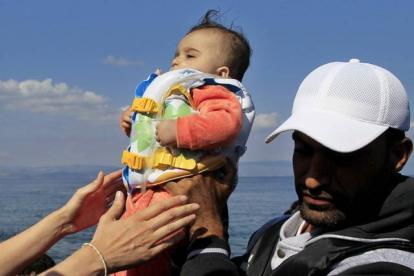 Un bebé llega a la isla griega de Mytilini tras salir de Turquía, este domingo.