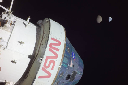 Fotografía del 28 de noviembre que muestra a la cápsula Orión de la misión Artemis I al momento de alcanzar una distancia de 432.210 kilómetros (268.563 millas) y al fondo la Luna y la Tierra. NASA