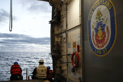 Marineros de la Armada del U.S.S. Portland (LPD 27) espera para cargar equipo en un bote pequeño como parte de la operación de recuperación de la cápsula Orión. CAROLINE BREHMAN