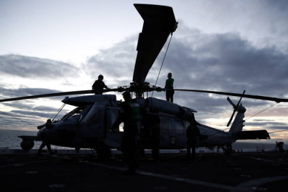 Los aviadores de la Marina del U.S.S. Portland (LPD 27) prepara helicópteros MH-60 para volar como parte de la operación de recuperación de la cápsula Orión. CAROLINE BREHMAN