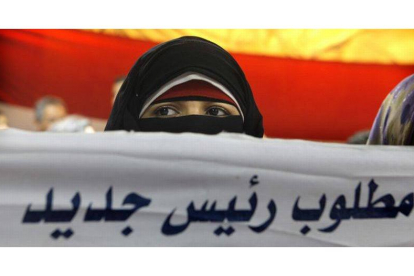 Una mujer egipcia sostiene el lema: "necesitamos un nuevo presidente".