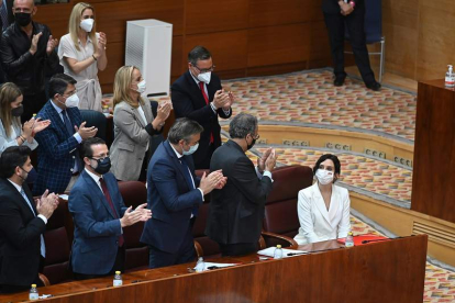 La bancada popular aplaude ayer a Isabel Díaz Ayuso en la Asamblea de Madrid. FERNANDO VILLAR