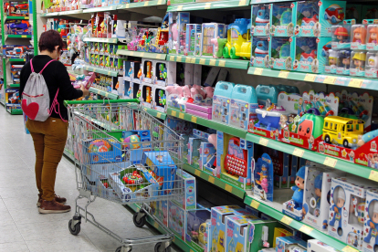 Una mujer compra en una tienda de juguetes. EFE